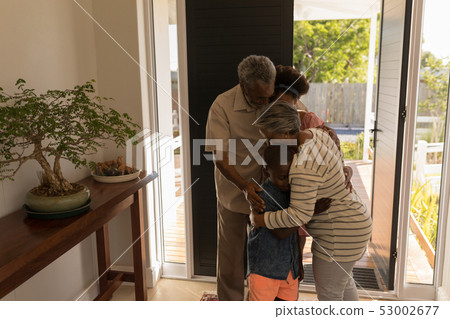 Grandparents embracing their grandchildren at home Grandparents embracing their grandchildren at home 53002677