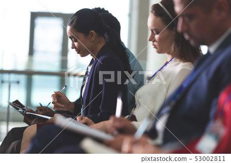 Business people writing on notepad in a business seminar 53002811