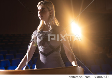 Businesswoman looking and thinking while standing on stage in auditorium 53002812