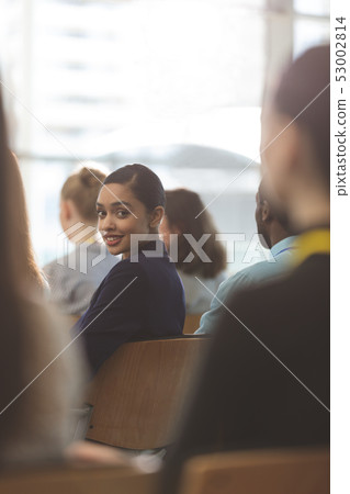 Happy young businesswoman looking at camera during seminar 53002814