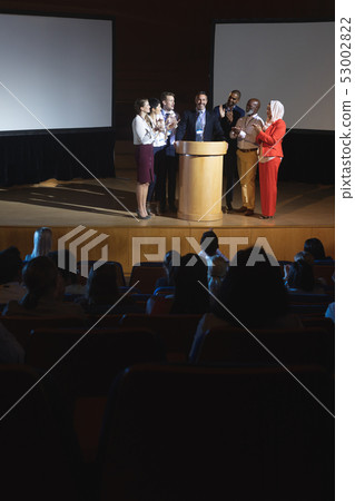 Business colleagues clapping hand for there colleague  for the success in the auditorium stage 53002822