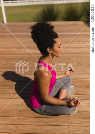 Woman meditating in the backyard of home 53002839