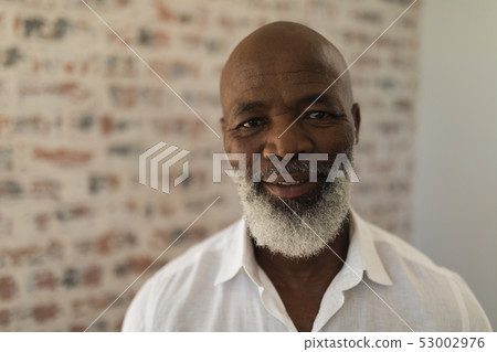 Black senior man smiling and standing at home 53002976