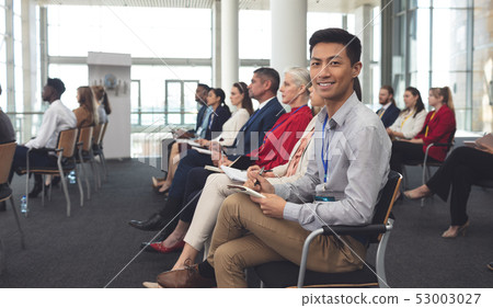 Happy businessman looking at camera in a seminar 53003027
