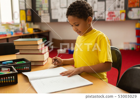 Schoolboy studying at desk in a classroom 53003029