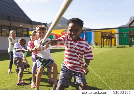 Group of school kids playing tug of war 53003195