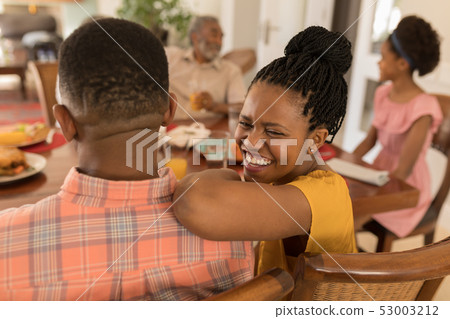 Multi-generation family having fun on dining table 53003212