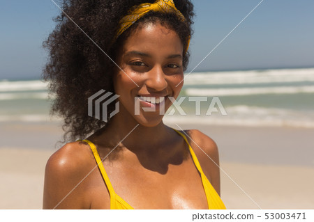 Young African American woman in yellow bikini looking at camera on the beach Young African American woman in yellow bikini looking at camera on the beach 53003471