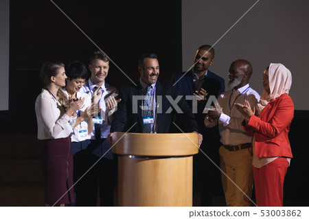 Business colleagues clapping hand for there colleague for the success in the auditorium stage Business colleagues clapping hand for there colleague for the success in the auditorium stage 53003862