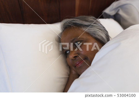 Senior woman lying in bed at home Senior woman lying in bed at home 53004100