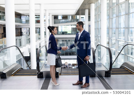 Young mixed-race business people shaking hand in modern office Young mixed-race business people shaking hand in modern office 53004101