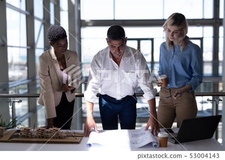 Multi-ethnic architects working at desk in office 53004143