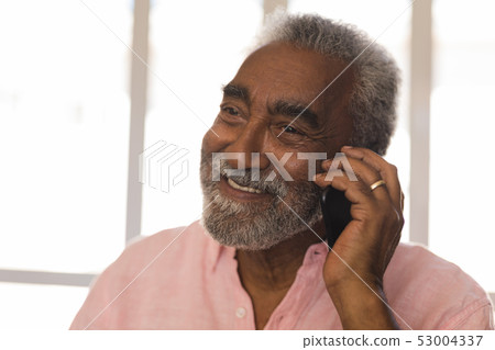 Senior man talking on mobile phone at home Senior man talking on mobile phone at home 53004337