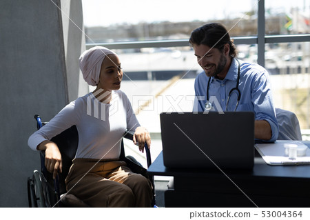 Disabled mixed-race woman and Caucasian male doctor interacting with each other Disabled mixed-race woman and Caucasian male doctor interacting with each other 53004364