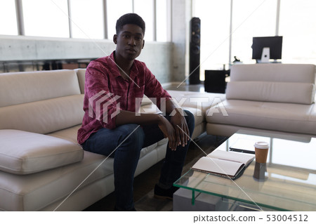 Male executive relaxing on a sofa in the office Male executive relaxing on a sofa in the office 53004512