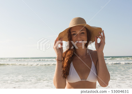 Young Caucasian woman in hat and bikini on the beach Young Caucasian woman in hat and bikini on the beach 53004631