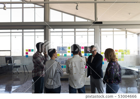 Business colleagues discussing over chart in office 53004666
