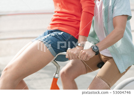 Caucasian couple enjoying bicycle ride at beach on a sunny day 53004746