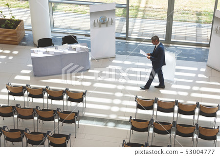 Businessman practising speech in empty conference room 53004777