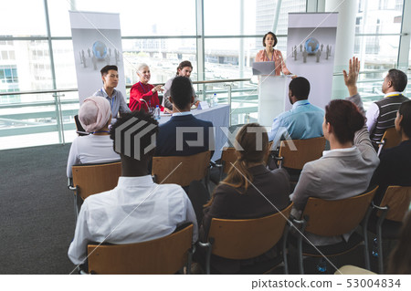 Businesswoman raising hand in a business seminar Businesswoman raising hand in a business seminar 53004834