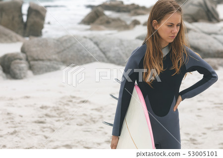 Woman standing on beach with hand on hip Woman standing on beach with hand on hip 53005101