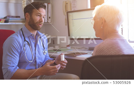 Male doctor and senior woman interacting with each other in clinic Male doctor and senior woman interacting with each other in clinic 53005926