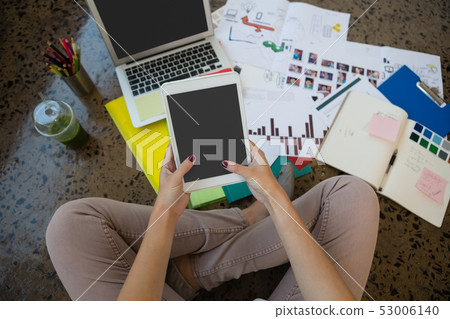 Woman using digital tablet at office Woman using digital tablet at office 53006140