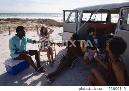 Group of friends toasting beer bottles at beach 53006143