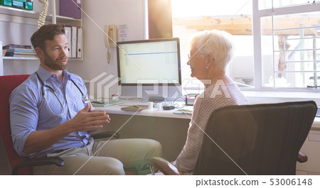 Male doctor and senior woman interacting with each other in clinic 53006148