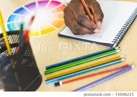 Graphic designer drawing a sketch on notebook art desk Graphic designer drawing a sketch on notebook art desk 53006225