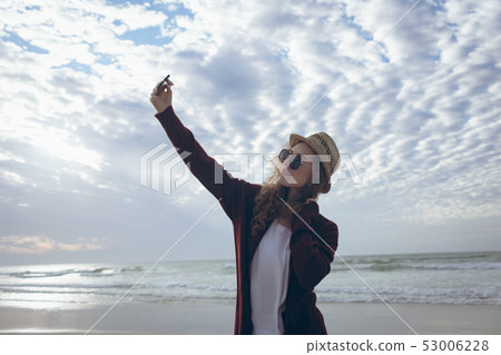 Beautiful woman taking selfie at beach Beautiful woman taking selfie at beach 53006228