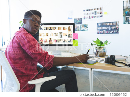 Graphic designer working on graphic tablet at desk in office 53006462