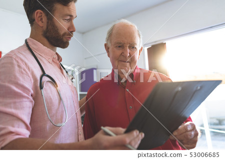 Male doctor showing medical report to a senior patient 53006685