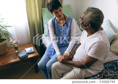 Female doctor and senior male patient interacting with each other Female doctor and senior male patient interacting with each other 53006744