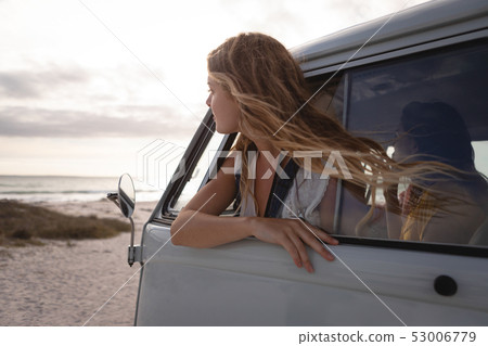 Side view of a Caucasian woman in a camper van with his head outside  53006779