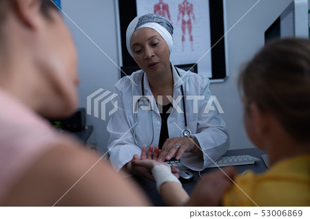 Matured female doctor examining girl hand in clinic 53006869