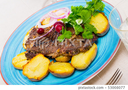 Beef steak with slices of baked potato Beef steak with slices of baked potato 53008077