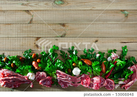 Raw lamb meat with vegetables on wooden background 53008848