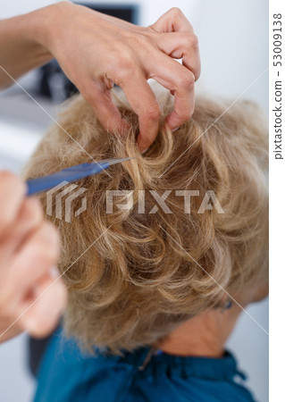Hands of hairdresser making hairstyle for female Hands of hairdresser making hairstyle for female 53009138