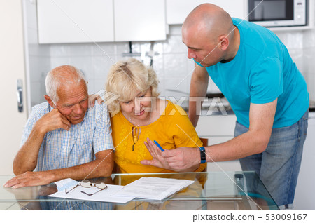 Upset old husband and wife signing agreement papers with social worker Upset old husband and wife signing agreement papers with social worker 53009167