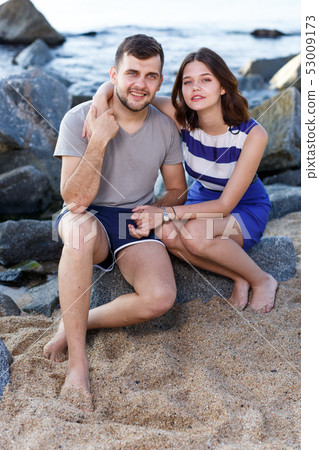 Young loving couple sitting and hugging Young loving couple sitting and hugging 53009173