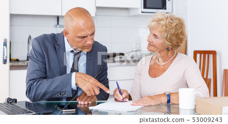 Senior woman signs document about purchase Senior woman signs document about purchase 53009243