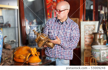 Man choosing ancient things in store Man choosing ancient things in store 53009248