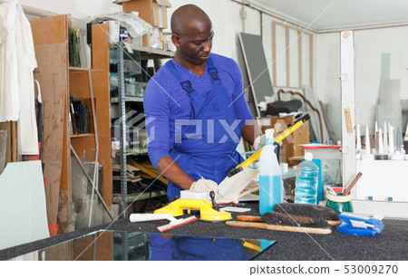 glass factory worker noting measurement or order data in notebook glass factory worker noting measurement or order data in notebook 53009270
