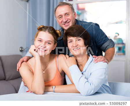 Portrait of marrieds with their adult daughter at the table 53009297