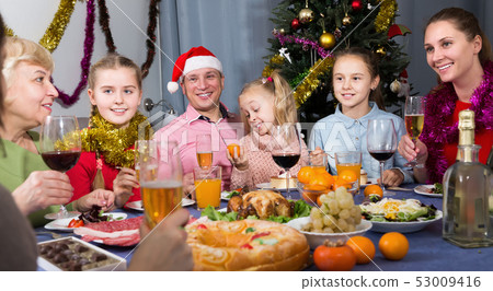 Happy family with kids talking at table celebration Christmas Happy family with kids talking at table celebration Christmas 53009416