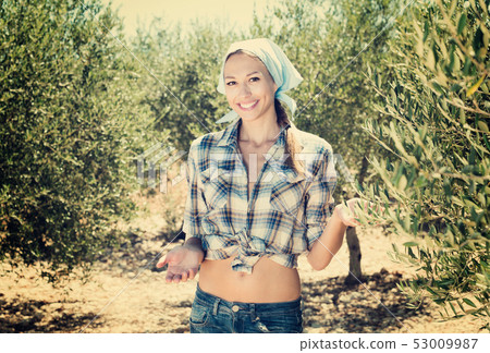 Woman gardener standing among olive trees 53009987