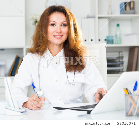 Portrait of therapist woman who is sitting behind laptop 53010071