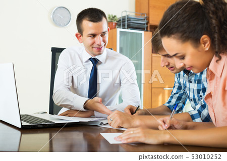 Spouses and salesman with documents 53010252