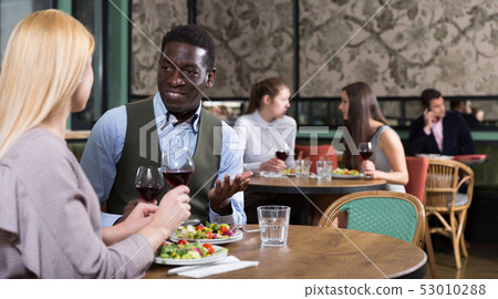African American businessman with female partner in restaurant 53010288